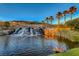 Serene waterfall flowing into a pond, surrounded by palm trees at 70 Portezza Dr, Henderson, NV 89011