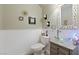 Small powder room with pedestal sink and decorative mirror at 7306 Puckershire St, Las Vegas, NV 89166