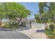 Single-story home with gray siding, mature tree, and attached two-car garage at 7456 Ute Meadows Cir, Las Vegas, NV 89129