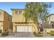 Two-story house with tan exterior, two-car garage, and landscaping at 8031 Tank Loop St, Las Vegas, NV 89166