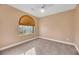 Well-lit bedroom with arched window and ceiling fan at 8220 Fawn Heather Ct, Las Vegas, NV 89149