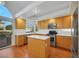 Kitchen with island, stainless steel appliances, and wood cabinets at 8220 Fawn Heather Ct, Las Vegas, NV 89149