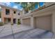 Inviting condo exterior with garages, a blue door, and well-kept landscaping at 840 Picotte St # 101, Las Vegas, NV 89144