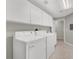 The laundry room has a tile floor with a washer, dryer, sink and white cabinets at 840 Picotte St # 101, Las Vegas, NV 89144