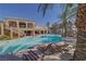 Community swimming pool with lounge chairs and palm trees at 8777 W Maule Ave # 1094, Las Vegas, NV 89148