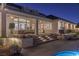 Backyard patio with seating area and lit steps leading to the pool at 9390 Stange Ave, Las Vegas, NV 89129