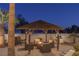 Relaxing patio area with thatched roof gazebo and fire pit at 9390 Stange Ave, Las Vegas, NV 89129