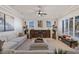 Bright living room with sectional sofa, views, and a rustic wooden media console at 9390 Stange Ave, Las Vegas, NV 89129