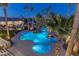 Inviting freeform pool and spa at night with palm trees surrounding at 9390 Stange Ave, Las Vegas, NV 89129