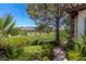 Landscaped backyard with a pathway, lush greenery, and a view of a golf course at 1 Panorama Crest Ave, Las Vegas, NV 89135