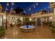 Evening view of a beautifully lit courtyard with a fountain and fireplace at 1 Panorama Crest Ave, Las Vegas, NV 89135