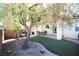 Landscaped backyard with patio furniture and large tree at 10418 Prairie Mountain Ave, Las Vegas, NV 89166