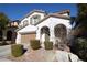 Two-story house with a tan garage door and landscaping at 10418 Prairie Mountain Ave, Las Vegas, NV 89166