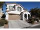 Two-story house with a tan garage door and landscaping at 10418 Prairie Mountain Ave, Las Vegas, NV 89166