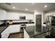 Modern kitchen with white cabinets, granite island, and stainless steel appliances at 10418 Prairie Mountain Ave, Las Vegas, NV 89166