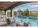 Covered patio with seating area overlooking a sparkling pool and water feature at 11952 Girasole Ave, Las Vegas, NV 89138