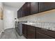 Laundry room with dark cabinets, granite counters, and modern appliances at 11952 Girasole Ave, Las Vegas, NV 89138