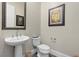 Stylish powder room with pedestal sink and wood-look tile floor at 11952 Girasole Ave, Las Vegas, NV 89138