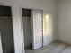 Bright bedroom with a double door closet and light gray floors at 1308 E Nelson Ave, North Las Vegas, NV 89030