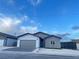 Inviting single-story home with a two car garage, featuring desert landscaping, gray and white exterior, and secure gated entry at 1308 E Nelson Ave, North Las Vegas, NV 89030