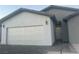 White two-car garage with gray accents and a paved driveway at 1308 E Nelson Ave, North Las Vegas, NV 89030