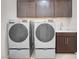 Bright laundry room, featuring washer, dryer, cabinets, and a utility sink at 131 Mosso Niente Pl, Henderson, NV 89011