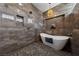 Elegant bathroom featuring a freestanding soaking tub and stone tile at 2548 Faiss Dr, Las Vegas, NV 89134