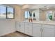 Bathroom with double vanity, large mirror, and wood-look flooring at 3354 Via Strada St, Henderson, NV 89044