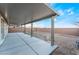 Covered back patio with a concrete slab, providing a comfortable outdoor living space with privacy walls at 3540 Valley Lily St, North Las Vegas, NV 89032