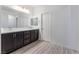 This modern bathroom has luxury vinyl flooring, a double sink, and a large mirror at 3540 Valley Lily St, North Las Vegas, NV 89032