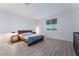 Cozy bedroom with minimalist décor, including wood frame bed, black dresser and wood-look floors at 3540 Valley Lily St, North Las Vegas, NV 89032