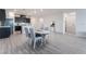 Open concept dining area features grey wood floors, white walls, and seating for four in a modern space at 3540 Valley Lily St, North Las Vegas, NV 89032