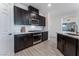 Modern kitchen with dark cabinets, white subway tile backsplash, and stainless steel appliances at 3540 Valley Lily St, North Las Vegas, NV 89032