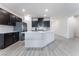 Modern kitchen with island, dark cabinets, and stainless steel appliances at 3540 Valley Lily St, North Las Vegas, NV 89032