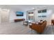 Bright living room with wood-look floors, modern furniture, and large windows at 3540 Valley Lily St, North Las Vegas, NV 89032