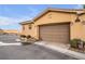 Two-car garage with a brown door and landscaping at 4 Via Centrale # 1, Henderson, NV 89011