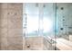 Elegant bathroom with marble tile, a soaking tub, and a glass shower at 4381 W Flamingo Rd # 1904, Las Vegas, NV 89103