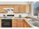 Kitchen with light wood cabinets, black appliances, and tile backsplash at 4439 Yellow Harbor St, Las Vegas, NV 89129