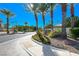 Landscaped entrance to the Tucson Ridge community with lush greenery and palm trees at 4620 Clay Peak Dr, Las Vegas, NV 89129