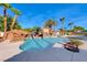 Stunning pool with a rock waterfall feature and lush landscaping at 4620 Clay Peak Dr, Las Vegas, NV 89129