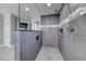 Modern walk-in shower featuring gray tiles, sleek fixtures, and built-in shelving at 4620 Clay Peak Dr, Las Vegas, NV 89129