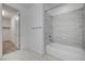 Modern bathroom with tub-shower combo, gray tile surround and white fixtures at 4807 Enchanted View St, Las Vegas, NV 89149