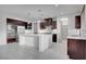 Modern kitchen with island, dark cabinets, and stainless steel appliances at 4807 Enchanted View St, Las Vegas, NV 89149