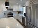 Modern kitchen with white shaker cabinets, quartz countertops, and stainless steel appliances at 5640 Judith Resnik Ct, Las Vegas, NV 89103