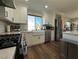 Modern kitchen with white cabinets, a farmhouse sink, and stainless steel appliances at 5640 Judith Resnik Ct, Las Vegas, NV 89103