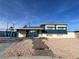 Ranch style home with blue exterior, gravel landscaping, and a paved driveway at 6124 Jones Cir, Las Vegas, NV 89107