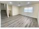 Bright living room with gray vinyl flooring and a view of the staircase at 6124 Jones Cir, Las Vegas, NV 89107