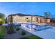 Stunning pool, spa, and outdoor kitchen area at dusk at 6188 Rockville Creek Ct, Las Vegas, NV 89149