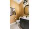 Stylish powder room with dark vanity, gold accents, and textured walls at 6188 Rockville Creek Ct, Las Vegas, NV 89149