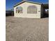 Tan mobile home with covered porch and large windows, side yard view at 6214 Mount Rainier Ave, Las Vegas, NV 89156